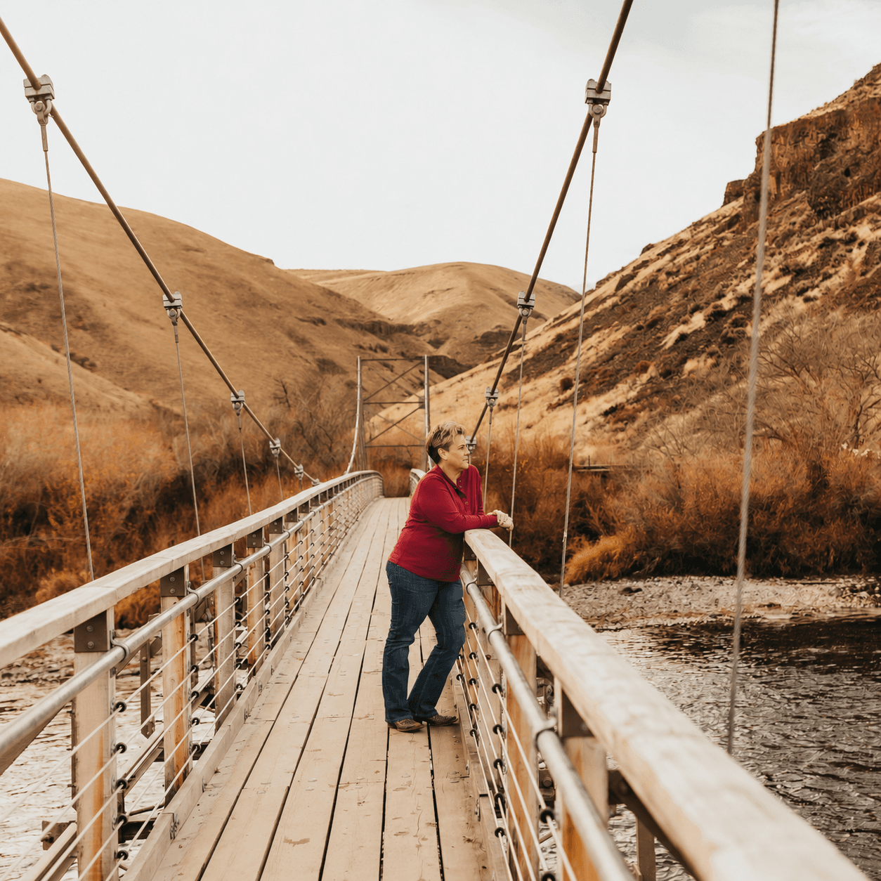 Jen Huber on a footbridge in the mountains