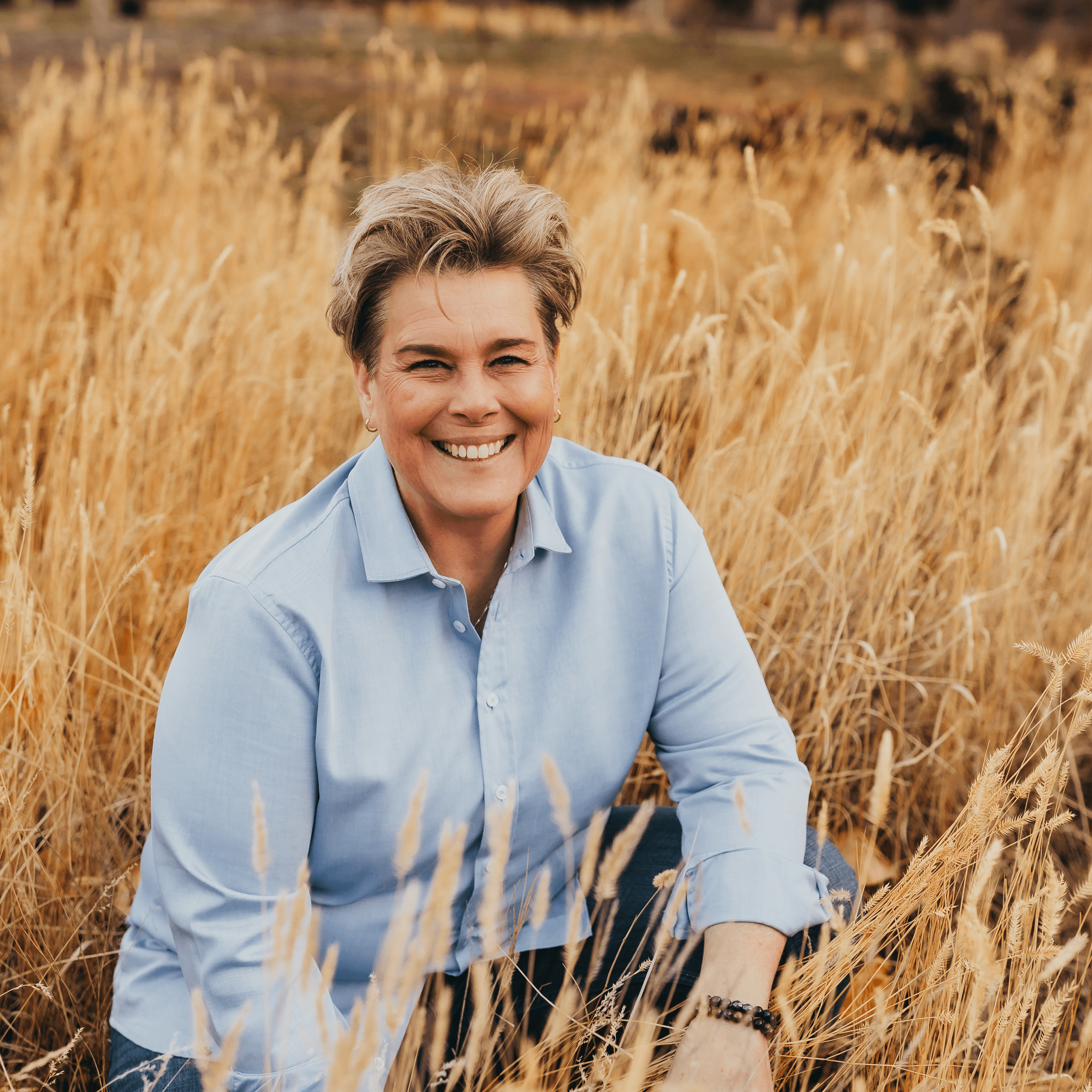 Jen Huber smiling in a field of tall grass